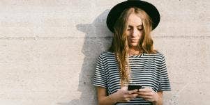 woman outside texting on cell phone