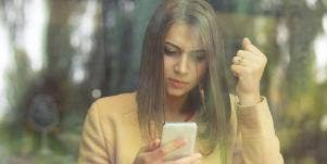 woman through a window looking at phone