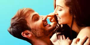 couple smiling at each other in front of a bright blue background