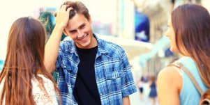 smiling man talking to two women