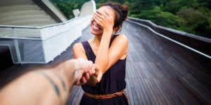 smiling woman covering her face with her hand in embarrassment