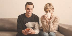 man texting beside a woman