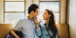 man and woman looking at one another on a train