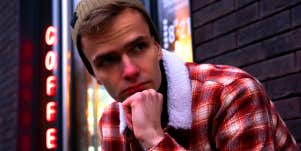 man wearing flannel and beanie outside coffee shop