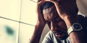 guy with hands on head crying