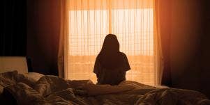 sad woman at window back turned