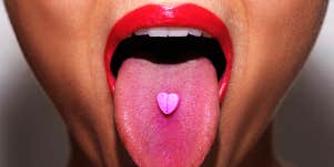 woman taking pink tablet