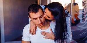 woman kissing man from behind