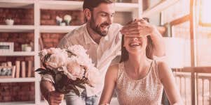 man handing flower to woman
