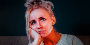 sad lonely woman with hand on cheek