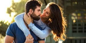 woman with arms around man's neck hugging from behind
