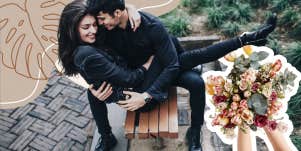 Couple sitting on a bench, hands full of flowers in grand gesture