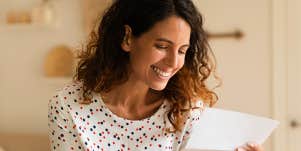 Smiling woman reads a letter