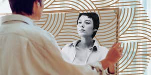 Woman looking at herself in mirror 