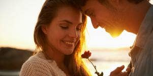 woman and man touching foreheads in sunset
