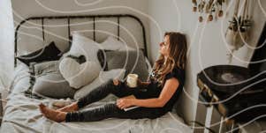 Woman sitting on bed drinking coffee 