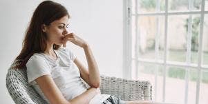 woman in white in thought by window