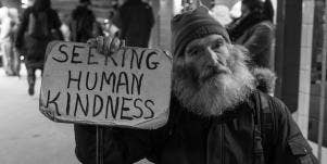 homeless man holding sign