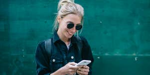 blonde woman in sunglasses texting 