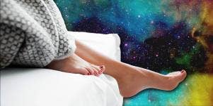 left foot hanging off the bed with a galaxy background