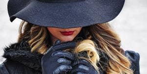 woman in black hat shielding eyes