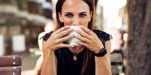 woman with blue eyes looking intensely over a cup