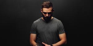 man looking down against black background