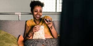 woman watching TV with popcorn