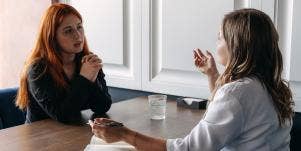 two women chatting together at table