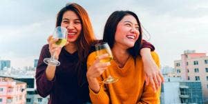 two women laughing and drinking