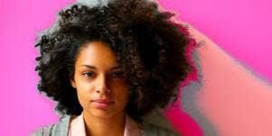 woman with serious face on pink background