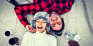 couple in cozy mountain clothes lying upside down on a blanket