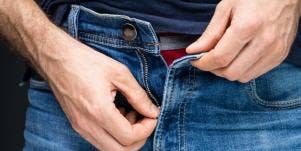 man unzipping pants