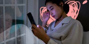 WOman sad on phone in bed