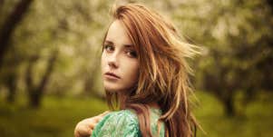 young strawberry blonde woman outdoors looking serious