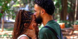 man kissing woman's forehead