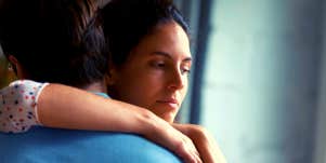 unhappy woman with her arm around her husband