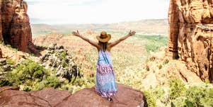 woman standing in Sonoma, arms out joyfully, wearing a sundress