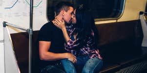 man and woman kissing on subway