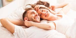 happy couple wearing white in bed