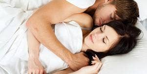 man and woman cuddling in bed