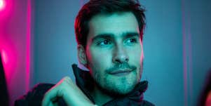 Man staring off-screen with neon background