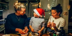 grandmother and mother cooking with child in santa hat