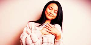 woman making a heart shape over her heart