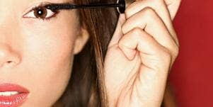 woman putting on mascara