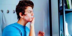 man doing skincare in mirror