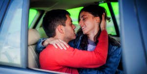 man and woman kissing in car