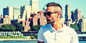 handsome man with grey hair against a city skyline 