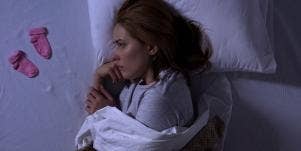 woman crying on bed