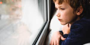 sad child looking out the window